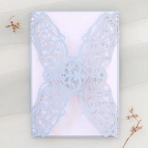 Détail du faire-part de mariage bleu clair découpé au laser avec motif papillon élégant