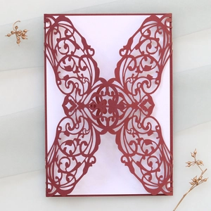 Détails de découpe laser florale sur une invitation de mariage bordeaux en forme de papillon