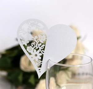 Dettaglio segnaposto a cuore con taglio laser e motivi floreali per matrimoni