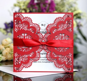 Elegant laser cut wedding invitation in red with a satin ribbon and white inner card