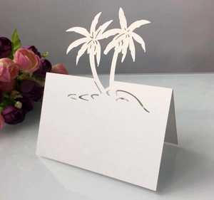 Detail of white laser-cut palm tree place card with vertical folding structure and waves