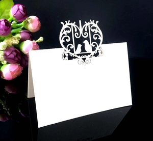 Macro detail of laser cut bird pattern on white place card for wedding table setting
