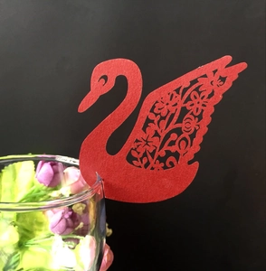 Red laser-cut swan paper place cards for wine glasses featuring floral hollow patterns