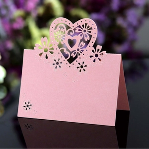 Marque-place cœur rose avec motifs floraux découpés au laser sur socle miroir