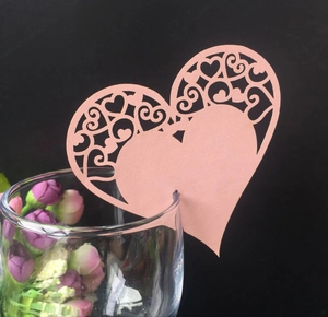Pink heart-shaped laser-cut place card attached to a wine glass for wedding table decor