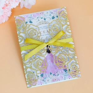 Detailed view of laser-cut glitter wedding invitation with golden bow and rose inner card