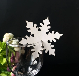 Laser cut white snowflake wine glass place card for elegant wedding table decor