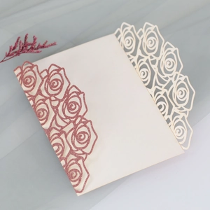 Detailed laser cut rose patterns and rose gold glitter on white wedding invitation cards