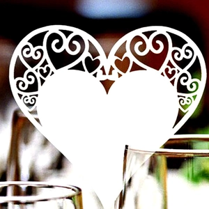White laser cut heart place card with intricate scrollwork for wedding table decor
