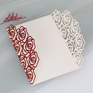 Laser cut rose wedding invitation with red glitter accents and cream white paper cover