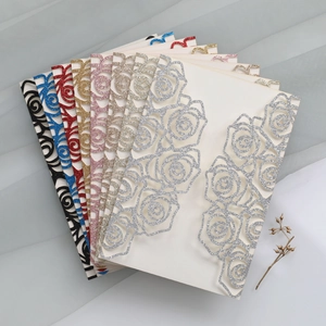 Macro view of assorted laser-cut glitter paper rose wedding invitation cards