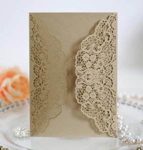Detailed laser-cut hollow lace design on a brown kraft paper wedding invitation card