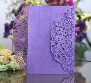 Detailed macro shot of laser-cut floral lace patterns on purple pearlescent paper invitation