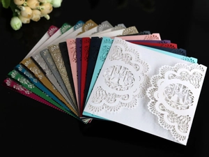 Macro detail of laser cut wedding invitations with bird and vine patterns in various colors
