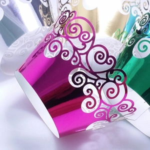 Vibrant pink metallic laser-cut cupcake wrappers with elegant swirling patterns