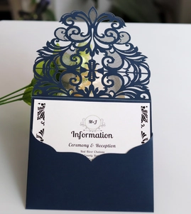 Détail macro d'un faire-part de mariage bleu marine découpé au laser avec motifs floraux
