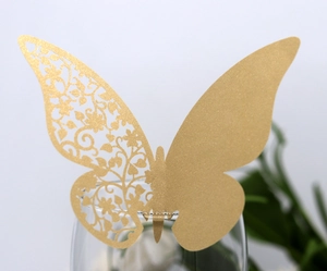 Close-up of laser-cut gold glitter butterfly card for wedding glass decoration