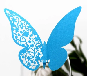 Macro shot of laser-cut blue butterfly card for wedding wine glass decoration