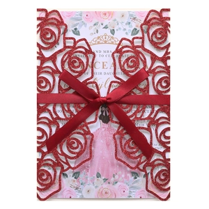 Detailed laser-cut rose wedding invitation with red glitter and golden ribbon bow