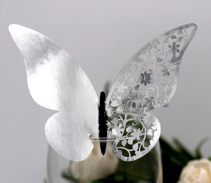 Macro view of silver laser-cut butterfly cup card with intricate floral lace texture