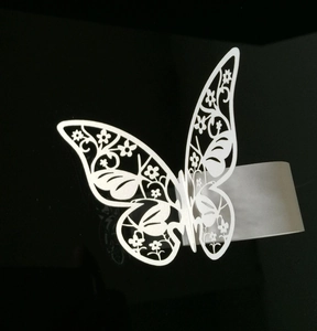Elegante servilletero de mariposa en papel blanco con patrones florales calados para bodas