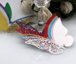 Macro shot of laser-cut paper butterfly cards for elegant wedding glass decoration
