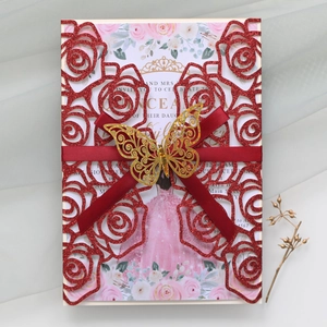 Detail of red laser cut glitter wedding invitation with golden butterfly and ribbon