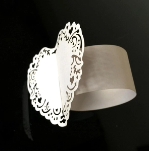 Detalle de patrón de corazón cortado por láser en servilletero de papel blanco