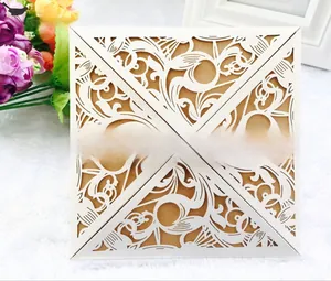 Intricate laser-cut ivory floral lace invitation with a silk bow and kraft paper insert