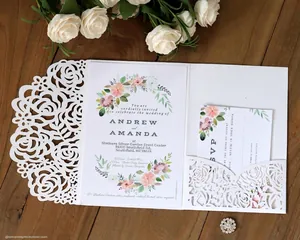 Laser cut wedding invitation with white rose filigree and floral card on wood