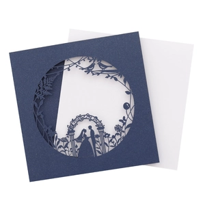 Navy blue laser-cut wedding invitation featuring bird and floral patterns on white background