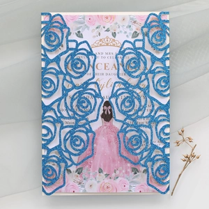 Close-up of laser cut glitter wedding invitation with blue floral rose and crown design