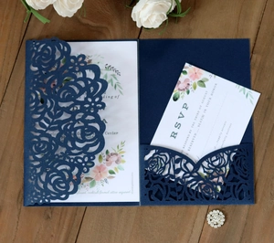 Detail of laser-cut navy rose lace wedding invitation with white floral RSVP card