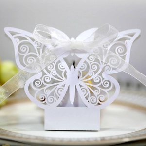 Elegant laser-cut white butterfly candy box with intricate patterns and white satin ribbon