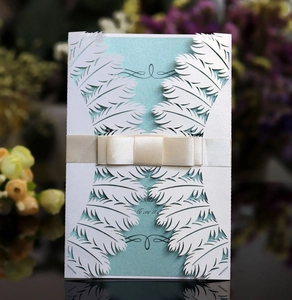 Detailed laser-cut white feather invitation with light blue inner and beige satin ribbon bow