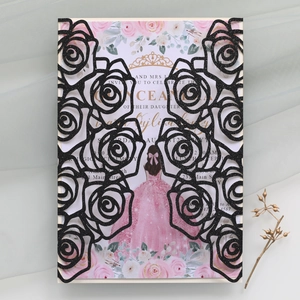 Detail of laser-cut black rose invitation cover with floral inner card and gold butterfly