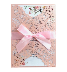 Pink laser-cut wedding invitation card with ribbon bow and floral interior insert