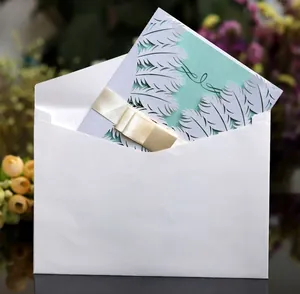 White feather laser-cut invitation card set with mint green insert and gold ribbon bow