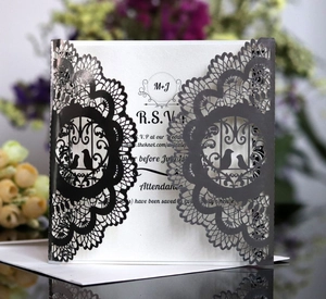 Intricate laser-cut wedding RSVP card with dark gray lace, floral patterns and bird motifs