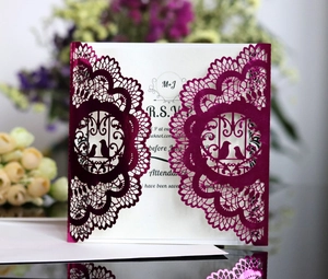 Detail of laser-cut wedding invitation with elegant birds and lace patterns in purple