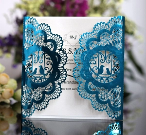 Detailed laser-cut wedding invitation featuring blue lace patterns and love birds