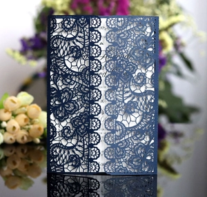 Detail showing deep blue laser cut lace invitation with elegant white inner card