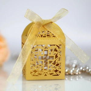 Detail of laser-cut cross pattern and golden ribbon on European style wedding candy box