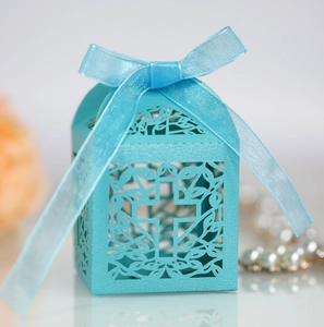 Detail of laser-cut cross hollow candy box with ribbon for weddings and religious events