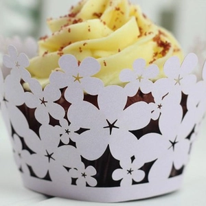 Pink laser-cut floral cupcake wrappers with intricate flower patterns for party decor