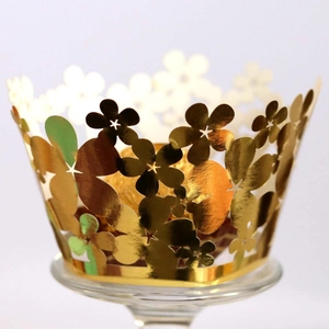 Laser cut hollow flower cake wrappers in shiny gold finish for elegant dessert display