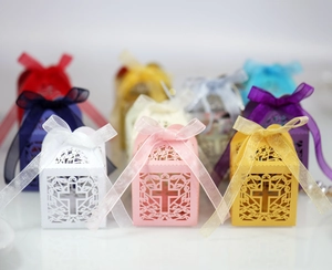 Detail of laser-cut cross patterns and organza ribbons on multi-color wedding gift boxes
