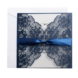 Elegant navy blue laser-cut wedding invitation with lace floral texture and ribbon