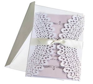 Elegant white laser-cut wedding invitation with lavender insert and white ribbon bow