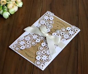 Vue détaillée de l'invitation de mariage découpée au laser avec ruban en satin
